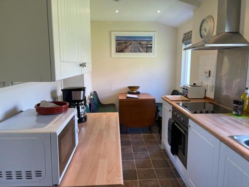 a kitchen with a microwave and a stove top oven at Burnside Cottage on the Blarich Estate in Rogart
