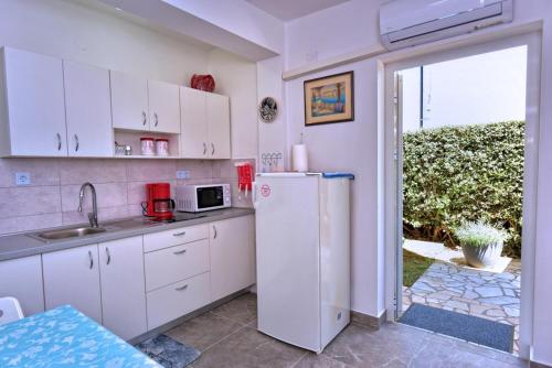 een keuken met witte kasten en een koelkast bij Apartment Gerber Krk in Krk