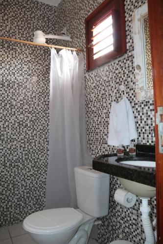 La salle de bains est pourvue de toilettes et d'un lavabo. dans l'établissement Villa Arte Pousada Morro Branco, à Beberibe