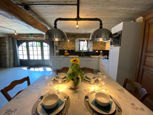 a kitchen with a table with a vase of flowers on it at Le Scailleteux - Gîte de charme clôturé, accès à la rivière in Fauvillers