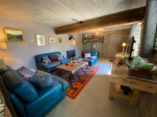 a living room with blue couches and a table at Le Scailleteux - Gîte de charme clôturé, accès à la rivière in Fauvillers