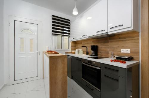 a kitchen with white appliances and a white door at Villa Alexandra in Boukari