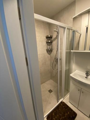 a bathroom with a shower and a sink at Apartamentai Kunigiškėse in Palanga
