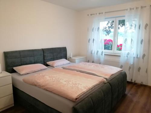 un letto grande in una stanza con una finestra di Ferienwohnungen Rosenhof a Karlstadt