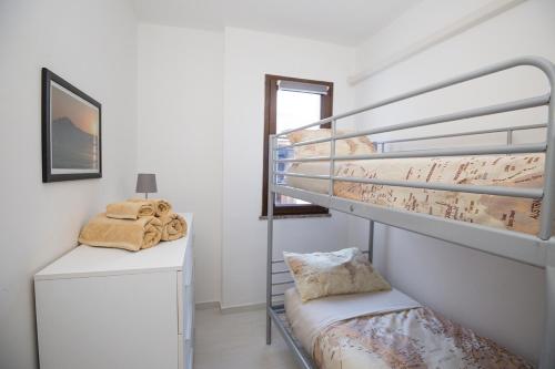 a room with two bunk beds and a desk at La Piazzetta in Lotzorai