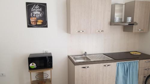 a small kitchen with a sink and a microwave at Case vacanza Controvento in Palermo