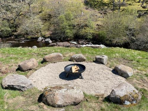 a fire pit sitting on top of a pile of rocks at Burnside Cottage on the Blarich Estate in Rogart