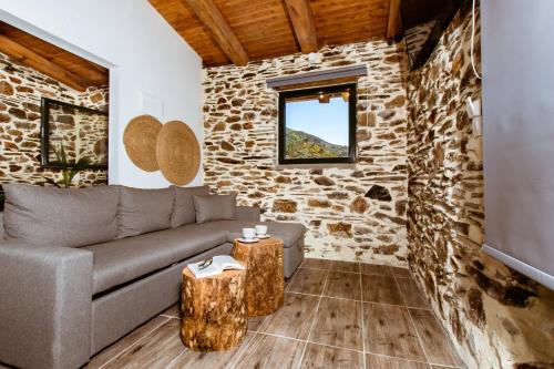 a living room with a couch and a stone wall at Traditional Apartments Elafos in Elafonisi