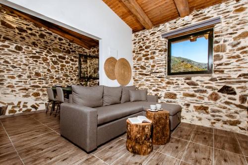 a living room with a couch and a stone wall at Traditional Apartments Elafos in Elafonisi