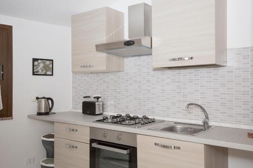 a kitchen with a sink and a stove top oven at La Piazzetta in Lotzorai