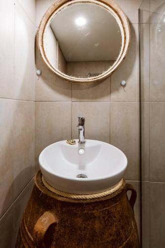 a bathroom with a sink and a mirror on the wall at Traditional Apartments Elafos in Elafonisi