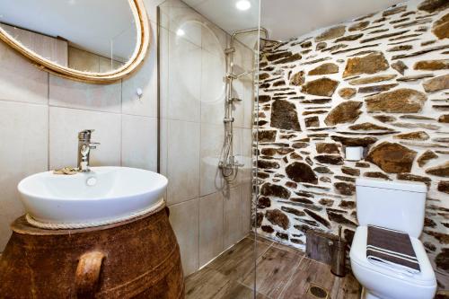a bathroom with a sink and a stone wall at Traditional Apartments Elafos in Elafonisi