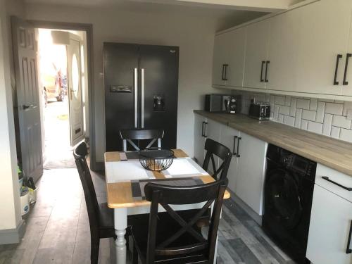 a kitchen with a table and chairs and a refrigerator at Rowan Place 5 Bedroom Off Street Parking Accommodation in Durham