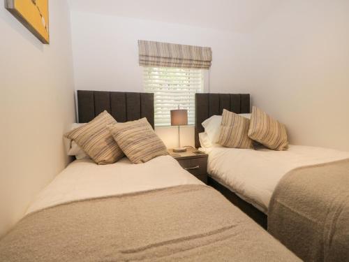 two beds sitting next to each other in a bedroom at Mere Brook Lodge in Windermere