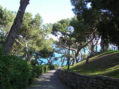 a street light next to a stone wall and trees at Old Town Lemon Charm in Bordighera