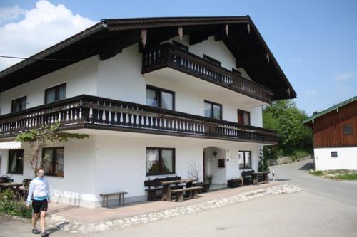 a man is standing in front of a building at Feichten-Hof Zaiser Zimmer in Schleching