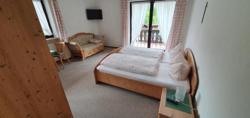 a bedroom with a bed and a window at Feichten-Hof Zaiser Zimmer in Schleching