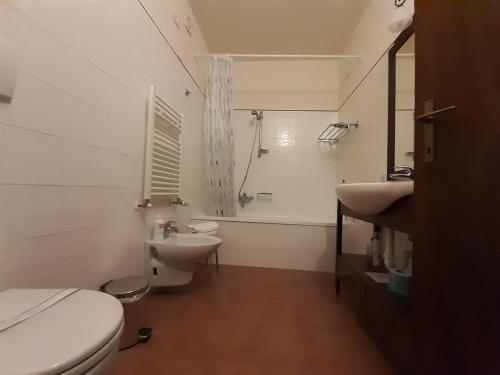 a white bathroom with a toilet and a sink at Appartamento Bilo in Borgo Magliano Resort in Magliano in Toscana