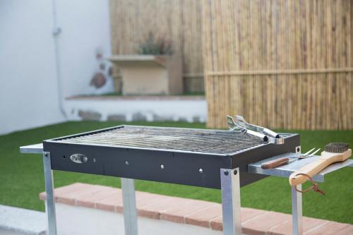 a barbecue grill with a pair of tongs on it at La Piazzetta in Lotzorai