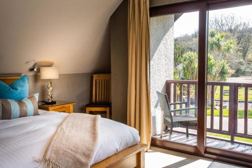 a bedroom with a bed and a balcony at Auchrannie Resort in Brodick