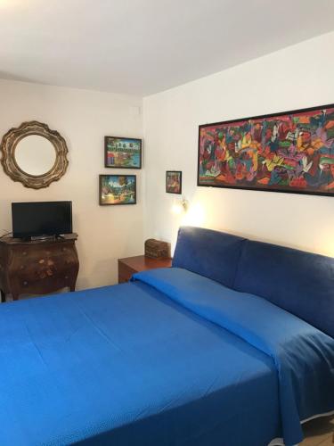 een slaapkamer met een blauw bed en een spiegel bij Villa Daniela in Quercianella