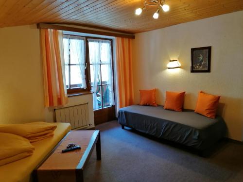 een woonkamer met 2 bedden en een bank bij Haus Bergwind in Sankt Leonhard im Pitztal