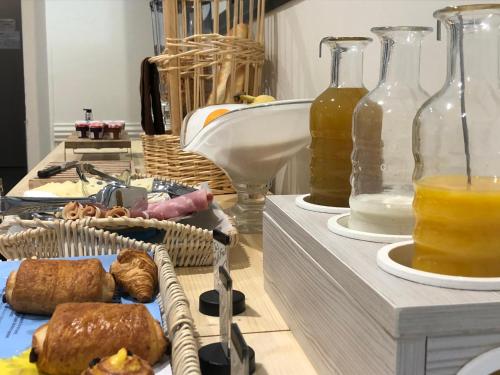 a table with two trays of food and bottles of juice at Hôtel et appartements les platanes in Thueyts