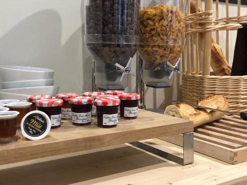 a group of jars of jam on a table with bread at Hôtel et appartements les platanes in Thueyts