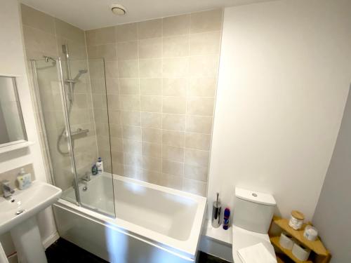 a bathroom with a shower and a toilet and a sink at Home Crowd Luxury Apartments in Doncaster