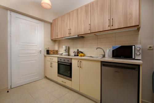 a kitchen with wooden cabinets and a microwave at Villa Alexandra in Boukari
