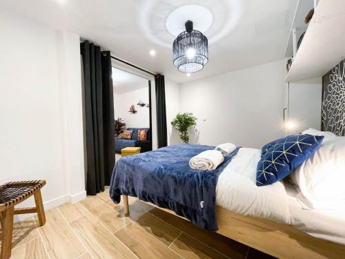 a bedroom with a large bed with blue and white pillows at LA GRACIEUSE - MILORA INN - Central Paris in Paris