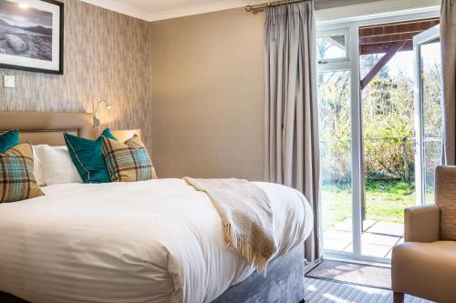 a bedroom with a bed and a sliding glass door at Auchrannie Resort in Brodick
