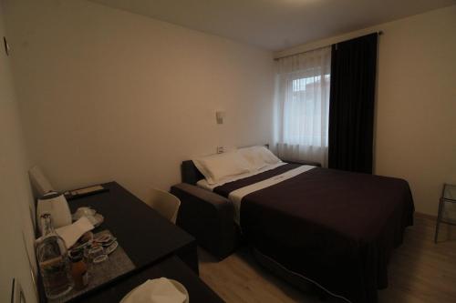 a small hotel room with a bed and a table at Hotel Cajeta in Buia