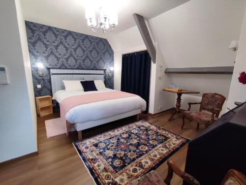 une chambre avec un lit, une table et une chaise dans l'établissement Aux Couleurs d'Esteil, à Sainte-Nathalène