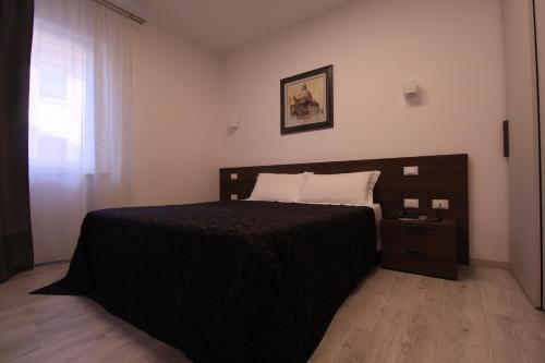 a bedroom with a black bed and a window at Hotel Cajeta in Buia