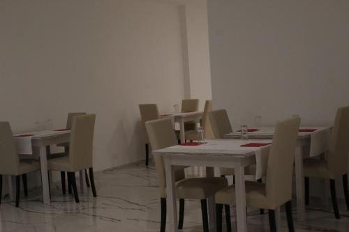 a dining room with white tables and chairs at Hotel Cajeta in Buia