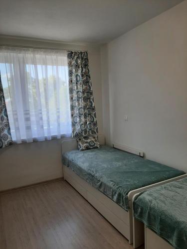 a small bedroom with a bed and a window at Apartmán Pri Jazere - Slnečné jazerá JUH in Senec