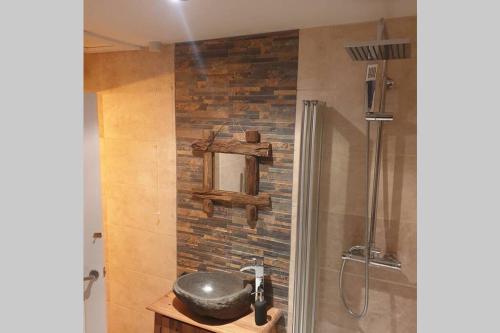 a bathroom with a shower and a stone wall at Cosy Cottage in Gainford