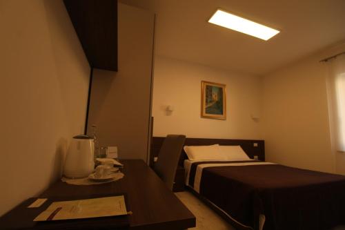 a hotel room with a bed and a table with a table at Hotel Cajeta in Buia