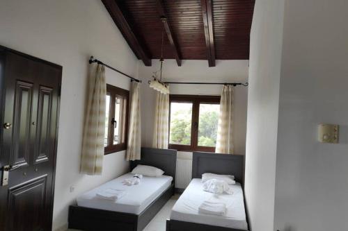 1 dormitorio con 2 camas y ventana en Artemis Penthouse 10 minute from national airport, en Artemida