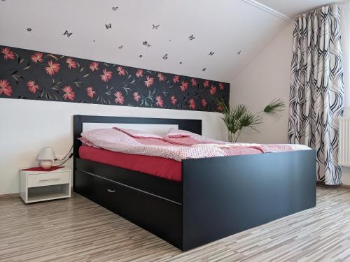 - une chambre avec un grand lit et des draps rouges dans l'établissement Pivnička pod Čachtickým hradom, à Čachtice