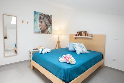 a bedroom with a bed with blue sheets and a mirror at Appartamento Limone in Splendida villa Nature al mare di Scopello Zingaro in Scopello