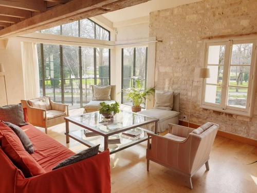 een woonkamer met banken en een glazen tafel bij QUAI 3 loft moderne et lumineux les pieds dans l'eau in Jarnac