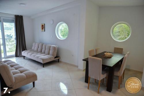 a living room with a dining room table and chairs at Resort Stikovic in Dobra Voda