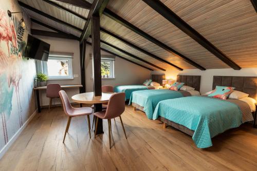 1 dormitorio con 2 camas, mesa y sillas en Villa Toscania-check in 24h, en Poznan