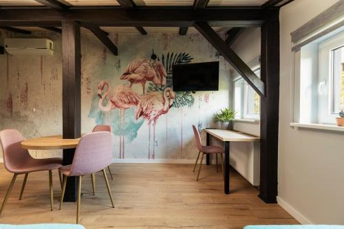 a dining room with a mural of flamingos on the wall at Villa Toscania-check in 24h in Poznań