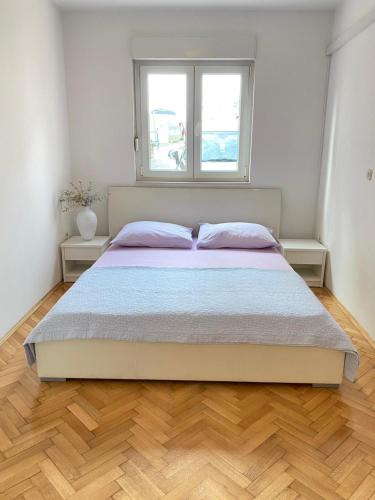 a bedroom with a large bed with a window at Apartman Krešo in Makarska