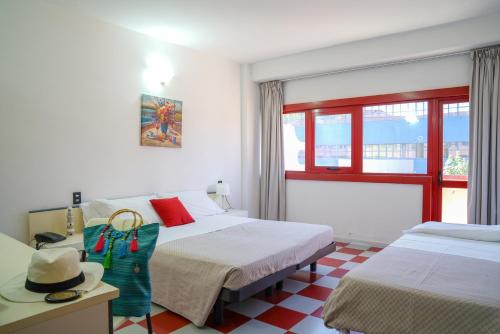 a hotel room with two beds and a window at Hotel Orizzonte in Silvi Marina