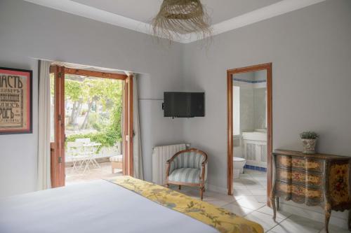 sypialnia z łóżkiem, krzesłem i oknem w obiekcie Villa Dora (Only adults) w mieście Jávea