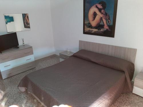 um quarto com uma cama e uma televisão em Casa Rosa em Crispiano